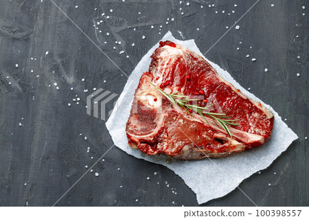 Raw fresh meat t-bone steak with spices on a dark background 100398557