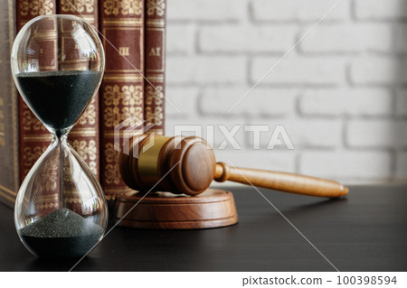 Court concept. Hourglass and judge gavel on table Court concept. Hourglass and judge gavel on table 100398594