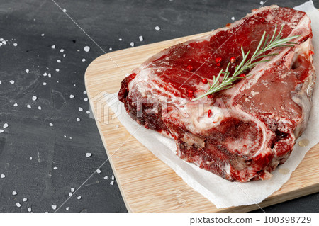 Raw fresh meat t-bone steak with spices on a dark background 100398729