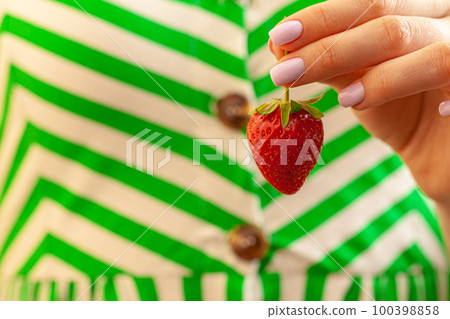 Beautiful large red strawberry in a hand 100398858