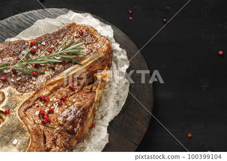 Top view of grilled t-bone steak on black table 100399104