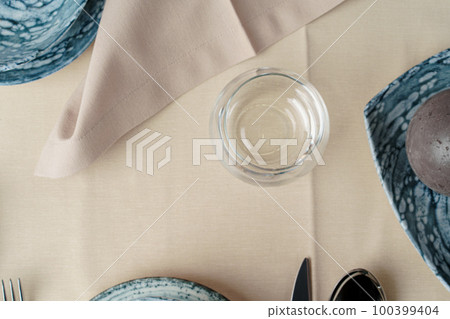 Details of a stylish table setting with textured ceramic dishes Details of a stylish table setting with textured ceramic dishes 100399404
