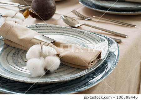 Table setting with stylish dishware on beige tablecloth Table setting with stylish dishware on beige tablecloth 100399440