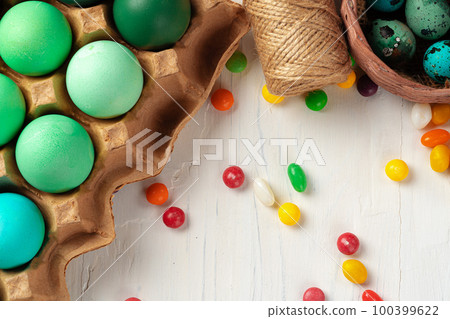 Colofrul Easter eggs and scattered candies on wooden table Colofrul Easter eggs and scattered candies on wooden table 100399622
