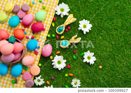 Colored eggs and vibrant candies on grass. Easter composition 100399927
