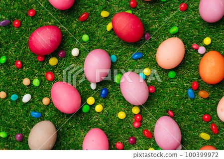 Colored eggs and vibrant candies on grass. Easter composition Colored eggs and vibrant candies on grass. Easter composition 100399972