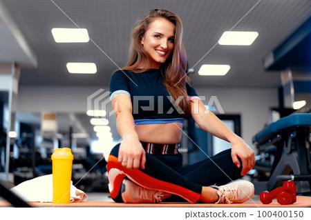 Woman fitness trainer portrait on a gym background Woman fitness trainer portrait on a gym background 100400150