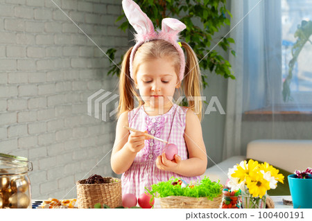 Little girl painting eggs for Easter at home Little girl painting eggs for Easter at home 100400191