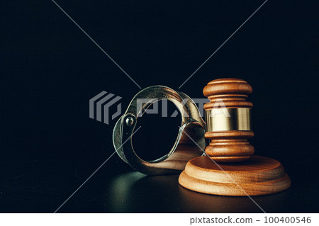 Judge gavel and handcuffs on dark black background 100400546