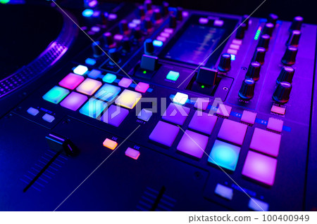 Close up of DJ mixing console in party light 100400949