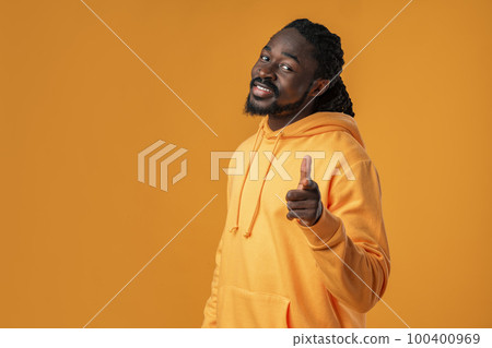 Handsome African man pointing you while standing against yellow background 100400969