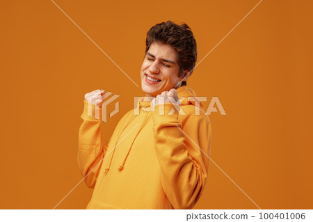 Young cheerful man dancing having fun over yellow background 100401006