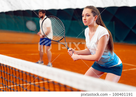 Pair of tennis players, man and woman waiting for service at indoor court 100401191
