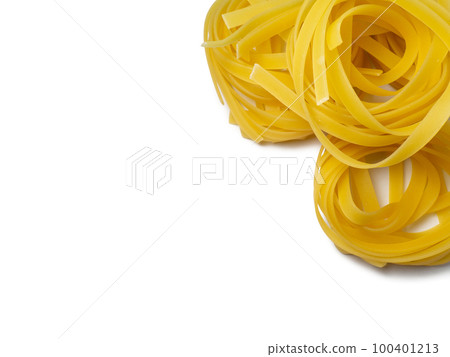 Pasta nests on a white background. Culinary background. Curled pasta on the table. Uncooked product.  Product made from flour and dough. Background from noodles. 100401213