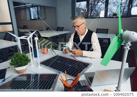 Male mature architect working on an ecological construction project in office Male mature architect working on an ecological construction project in office 100402075