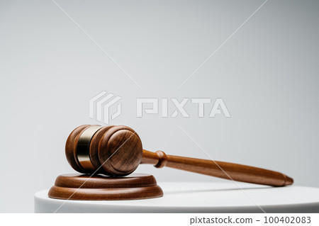Brown wooden judge gavel on gray background 100402083
