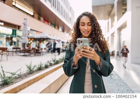 Young woman reading a message or using the phone in the city Young woman reading a message or using the phone in the city 100402154