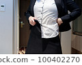 Woman changing into a skirt business suit 100402270
