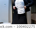 Woman changing into a skirt business suit 100402275