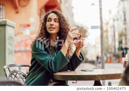 Woman tourist drinking traditional Turkish tea in outdoor cafe 100402475