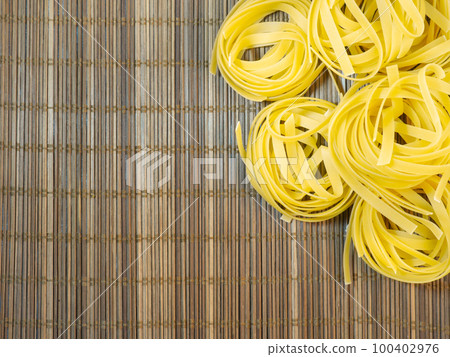 Pasta nests on a wicker background. Type of noodle. Culinary background. Cooking. Pasta nests on a wicker background. Type of noodle. Culinary background. Cooking. 100402976