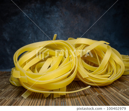 Pasta nests on a wicker background. Type of noodle. Culinary background. Cooking. 100402979