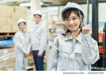 A female worker doing a guts pose in a warehouse A female worker doing a guts pose in a warehouse 100404700