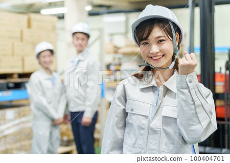 A female worker doing a guts pose in a warehouse A female worker doing a guts pose in a warehouse 100404701