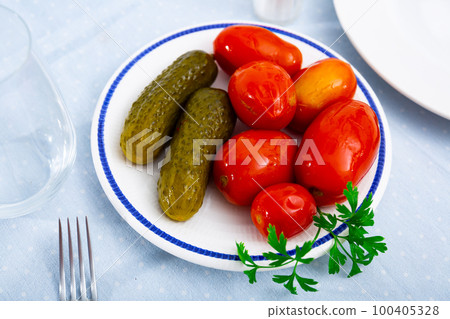 Homemade marinated tomatoes and cucumbers on plate 100405328