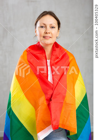 Adult woman wrapped in LGBT flag 100405329