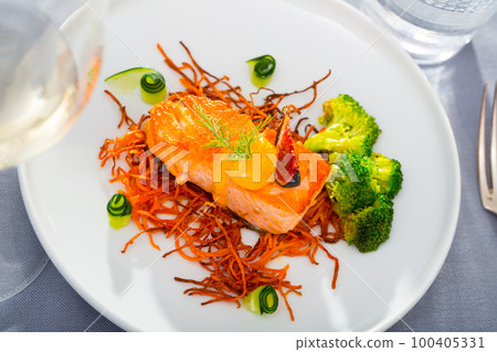 Steak of fried salmon with smoked carrots, broccoli, cucumbers and fig on plate Steak of fried salmon with smoked carrots, broccoli, cucumbers and fig on plate 100405331