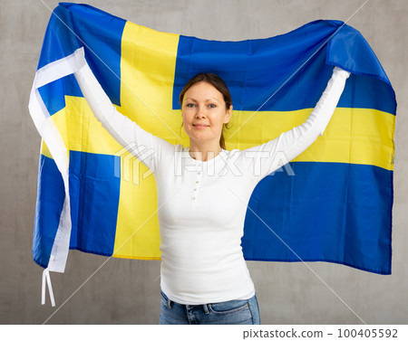 Happy smiling woman proudly displaying swedish flag Happy smiling woman proudly displaying swedish flag 100405592