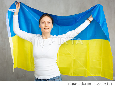 Happy smiling woman proudly displaying ukrainian flag Happy smiling woman proudly displaying ukrainian flag 100406103