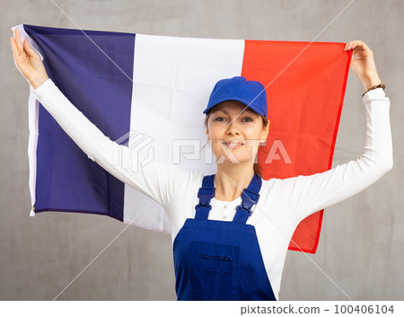 Cheerful female worker with wide grin on her face holding flag of france 100406104