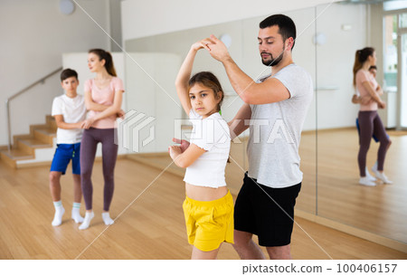 Teen girl practicing boogie-woogie in pair with father in dance studio Teen girl practicing boogie-woogie in pair with father in dance studio 100406157