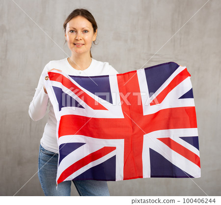 Happy woman posing with flag of United Kingdom in studio Happy woman posing with flag of United Kingdom in studio 100406244