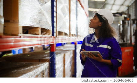 Young black woman warehouse workers holding digital tablet checking inventory management 100406405
