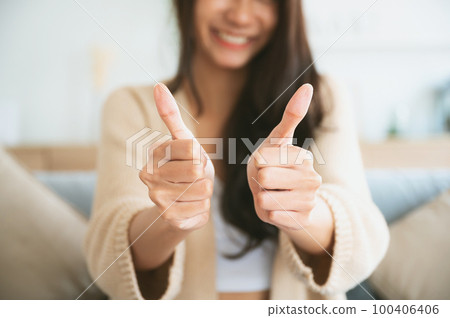 Happy teen asian girl blogger smiling face waving hand talking to webcam recording vlog 100406406