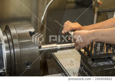 Close up scene the machine operator measuring outside diameter metal shaft parts by dial Vernier caliper. Close up scene the machine operator measuring outside diameter metal shaft parts by dial Vernier caliper. 100408662