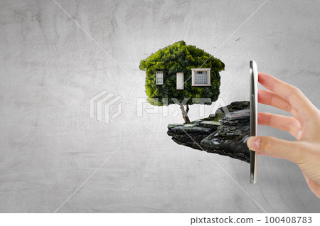 Hand holding green house . Mixed media 100408783