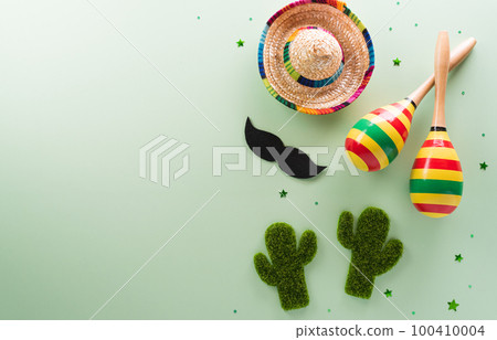 Cinco de Mayo holiday background made from maracas, mexican blanket stripes or poncho serape, cactus and hat on pastel background. Cinco de Mayo holiday background made from maracas, mexican blanket stripes or poncho serape, cactus and hat on pastel background. 100410004