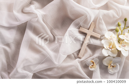 Good Friday and Holy week concept - A religious cross and flower on white fabric background. 100410009