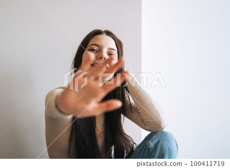 Young smiling woman teenager girl with dark long hair in jeans in her room at the home 100411719