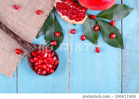 Ripe pomegranate fruits on the wooden background Ripe pomegranate fruits on the wooden background 100411908