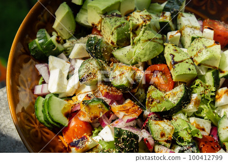 Avocado mix of vegetables salad in daytime outdoors. Fresh salad with tomatoes, avocado, lettuce onion cucumber. Healthy and detox food concept. Ketogenic diet Avocado mix of vegetables salad in daytime outdoors. Fresh salad with tomatoes, avocado, lettuce onion cucumber. Healthy and detox food concept. Ketogenic diet 100412799
