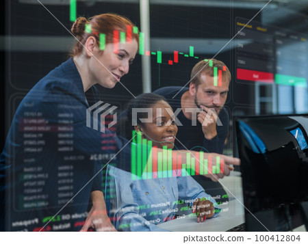Stock charts on a virtual screen. Colleagues look at the monitor and decide working moments in the office. Stock charts on a virtual screen. Colleagues look at the monitor and decide working moments in the office. 100412804