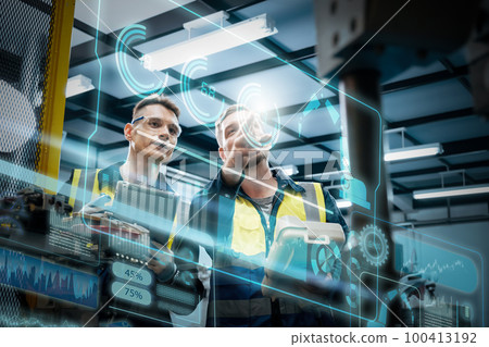 Multiracial technicial engineer training with robot arm Multiracial technicial engineer training with robot arm 100413192