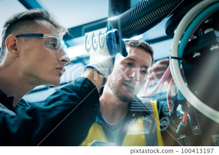 Multiracial technicial engineer training with robot arm Multiracial technicial engineer training with robot arm 100413197