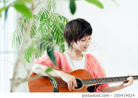 A young lady playing the guitar A young lady playing the guitar 100414024