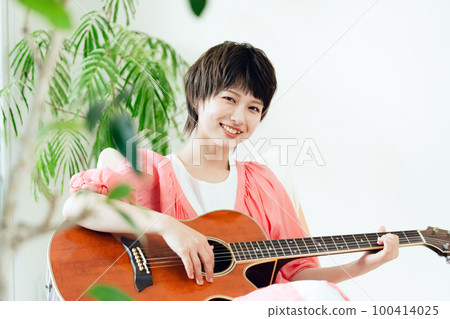 A young lady playing the guitar A young lady playing the guitar 100414025